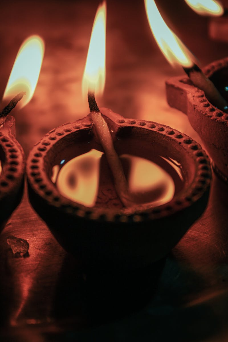 A close-up view of burning oil lamps, capturing the warm glow and cultural essence of Diwali in India.