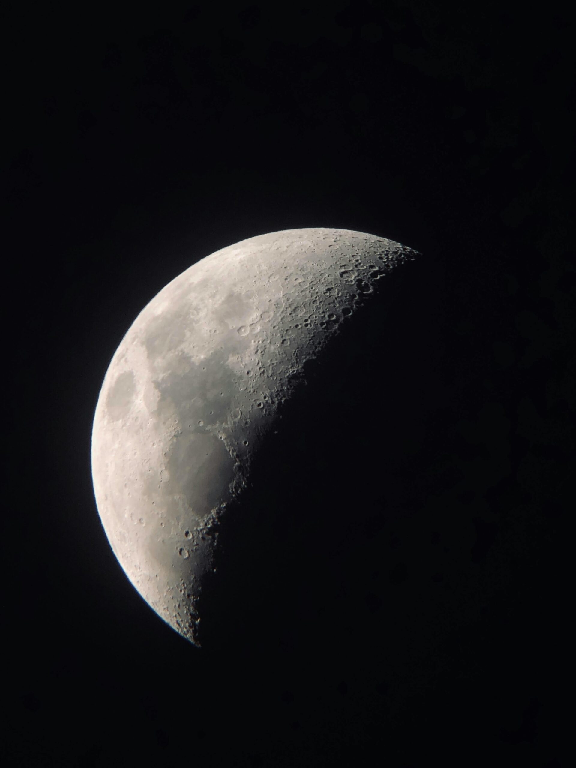 High-resolution image capturing the detailed surface of the crescent moon against a dark sky.