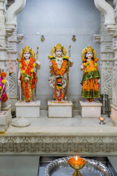 Decorative Hindu deity statues adorned with flowers inside a traditional Mumbai temple.